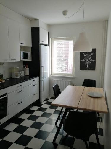 a kitchen with a wooden table and chairs in a kitchen at Parvekkeellinen huoneisto rantabulevardilla, 1-4 hengelle in Savonlinna