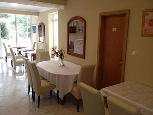 una sala da pranzo con un tavolo con sedie e un vaso di fiori di Villa Royal a Cavtat
