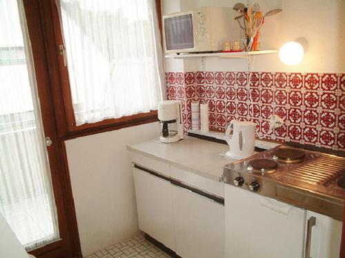 eine kleine Küche mit einem Herd und einer Arbeitsplatte in der Unterkunft Haus Reni in Büsum