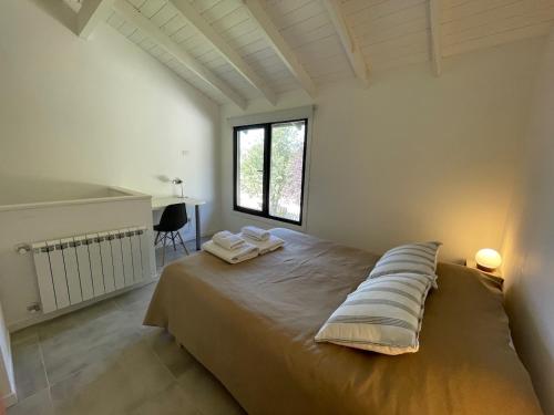 1 dormitorio con 1 cama con 2 almohadas en Cabaña con jardin en Dina Huapi