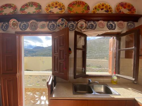 a kitchen with a sink and a window with plates on the wall at LoView Avlona 
