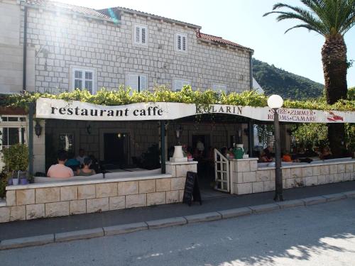a restaurant with people sitting outside of a building at Guest House Kolarin in Slano