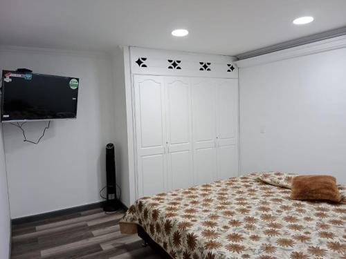 a bedroom with a bed and a flat screen tv at Medellin apartamento en laureles in Medellín