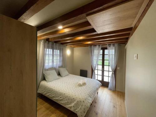 une chambre avec un lit avec des draps blancs et une fenêtre dans l'établissement Maison et dépendance haut de gamme proche de Deauville-Trouville, à Les Authieux-sur-Calonne