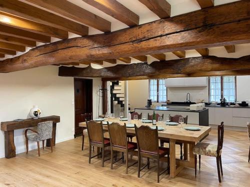 une salle à manger avec une grande table et des chaises en bois dans l'établissement Maison et dépendance haut de gamme proche de Deauville-Trouville, à Les Authieux-sur-Calonne