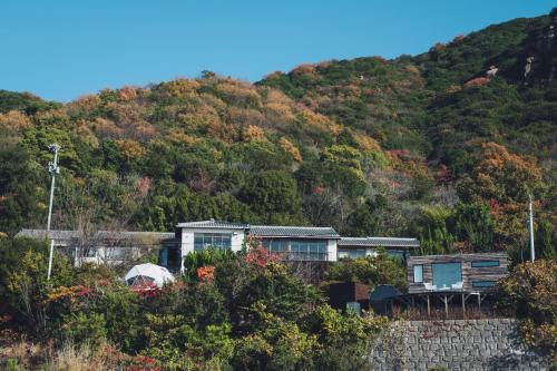 una casa en la ladera de una montaña en DENIM HOSTEL float, en Kurashiki