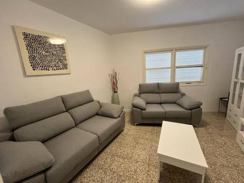 a living room with a couch and a table at Casa unifamiliar. Gran terraza. Vistas. Tele working in Los Realejos
