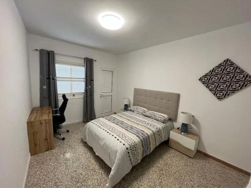 a bedroom with a bed and a desk and a chair at Casa unifamiliar. Gran terraza. Vistas. Tele working in Los Realejos