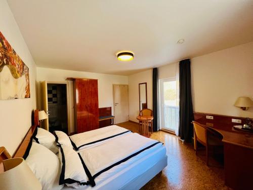 a hotel room with a bed and a desk and a bed sidx sidx at TheCrossing Bed & Breakfast in Hausen im Tal
