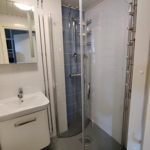 uma casa de banho com um chuveiro e um lavatório. em Huoneisto rantabulevardilla, 1-4 hengelle em Savonlinna