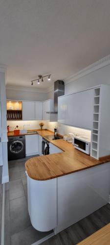 a large kitchen with a wooden counter top at Lakeview Apartment, central location, Sea and Lake view, free parking & WiFi in Southport