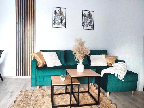 a living room with a green couch and a table at Apartament DanHouse in Giżycko