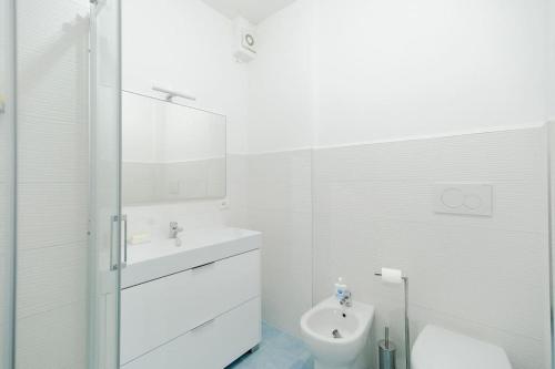 a white bathroom with a sink and a toilet at Appartamento a 20mt dal mare con piscina condominiale in Marcelli