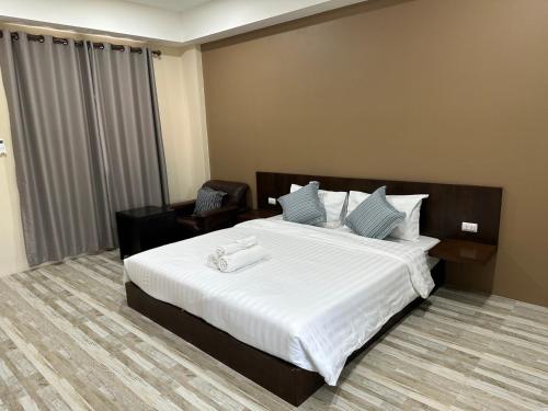 ein Hotelzimmer mit einem großen Bett mit weißer Bettwäsche in der Unterkunft Better Life Residence Phuket in Nai Yang Beach