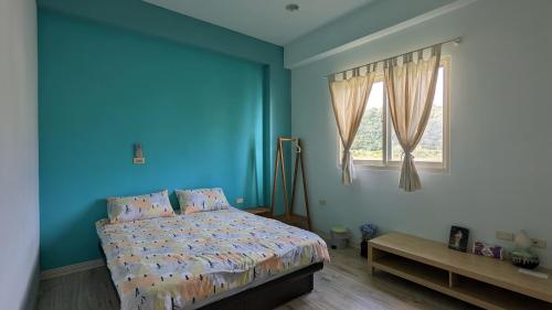 Dormitorio azul con cama y ventana en Tien Chon Xiao Lin Homestay en Jiaoxi