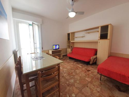 Habitación con cama roja y sofá rojo. en Ligure Residence, en Borgio Verezzi