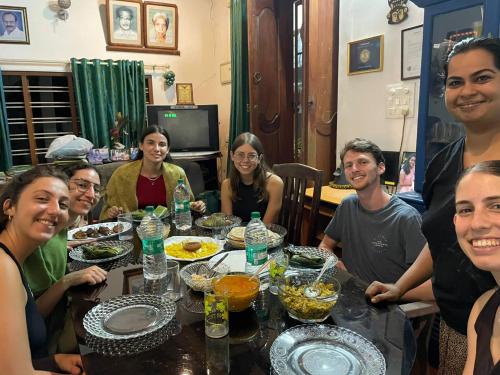 un gruppo di persone seduti intorno a un tavolo con cibo di Aleenas homestay a Cochin