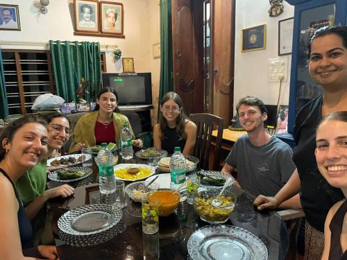a group of people sitting around a table with food at Aleenas homestay in Cochin