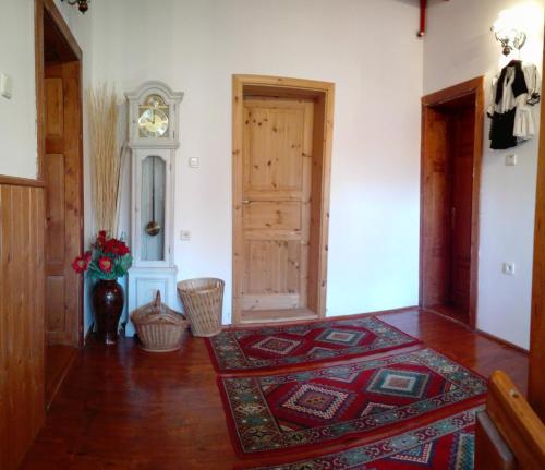 um quarto com uma porta, um tapete e um relógio em Apartvilla Serbota em Porumbacu de Sus