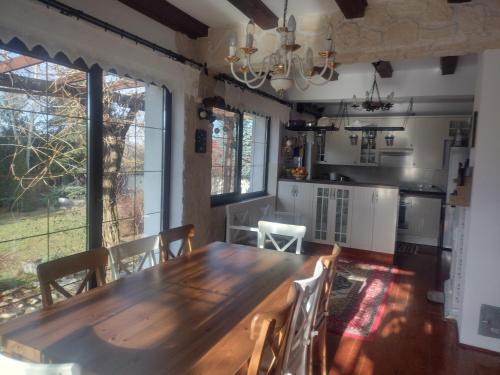 uma cozinha e sala de jantar com uma mesa de madeira e cadeiras em Apartvilla Serbota em Porumbacu de Sus