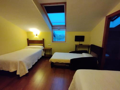 Una habitación de hotel con dos camas y una ventana. en Hotel Rural Corazón de las Arribes, en Aldeadávila de la Ribera