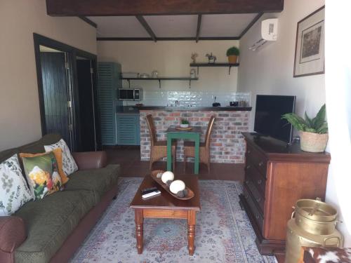 a living room with a couch and a table at Dunkes Organic Equestrian Estate in George