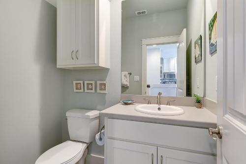 a white bathroom with a toilet and a sink at Beachy Keen in Port Aransas