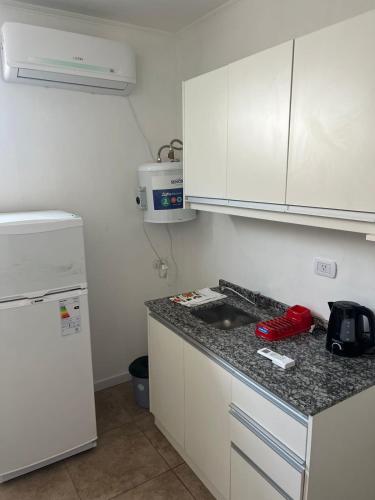 a kitchen with a sink and a white refrigerator at Departamento guemes D in San Pedro