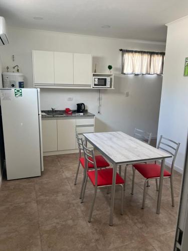 a kitchen with a table and chairs and a refrigerator at Departamento guemes D in San Pedro