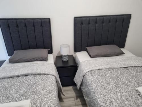 two beds sitting next to each other in a room at Modern Apartment good distance from Dublin City and Airport 4people in Dublin