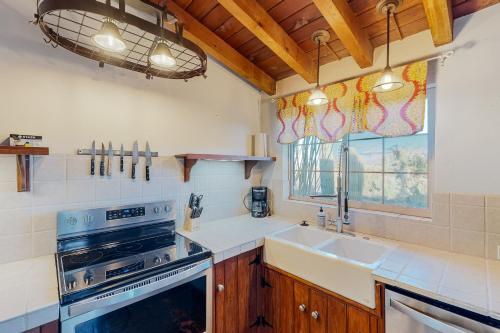 uma cozinha com um fogão, um lavatório e uma janela em Cactus Grove Main House em Tucson