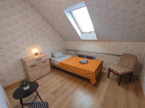 Schlafzimmer mit einem Bett, einem Schreibtisch und einem Fenster in der Unterkunft Birzītes 5 in Valmiera