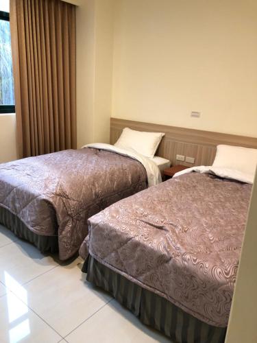 a hotel room with two beds and a window at Lohas Seaview B&B in Beigan