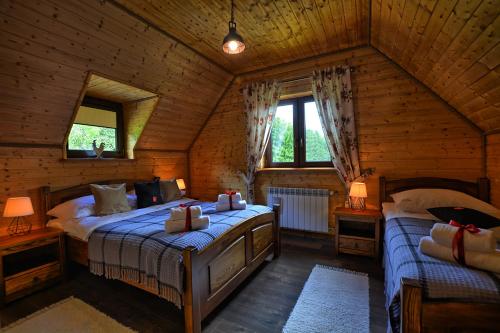 sypialnia z 2 łóżkami w drewnianym domku w obiekcie Stacja Żubracze w mieście Żubracze