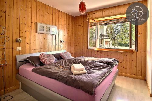 ein Schlafzimmer mit einem Bett in einer Holzwand in der Unterkunft Carving Residence in Ovronnaz