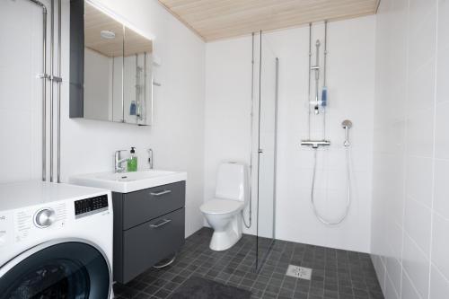 La salle de bains est pourvue d'un lave-linge et de toilettes. dans l'établissement Rauma City Center Studios, à Rauma