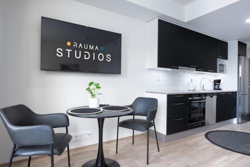 a kitchen with a table and chairs in a room at Rauma City Center Studios in Rauma