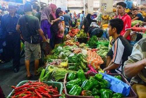 a group of people standing around a market with vegetables at Welcome,3R2B Cheerful Family's Homestays Sandakan. in Sandakan