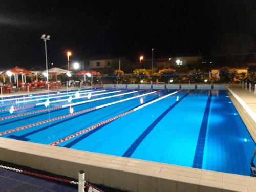 una gran piscina de agua azul por la noche en Appartamenti Capo Rizzuto, en Isola di Capo Rizzuto