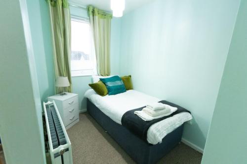 a small bedroom with a bed and a window at Bellengers Bee in Kidlington