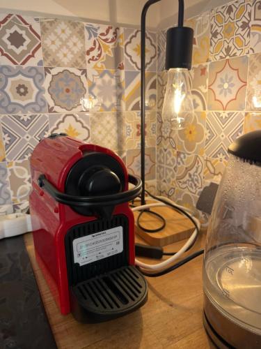 a red toaster sitting on top of a table at Maison confortable élégante et équipée pour un séjour idéal à Dakar in Dakar