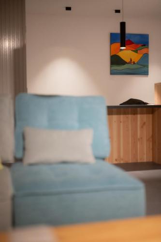 a blue couch in a room with a painting on the wall at L'Orée des Sources in Volvic
