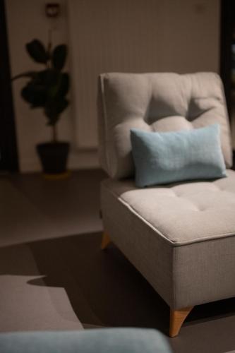 a white chair with a blue pillow on it at L'Orée des Sources in Volvic