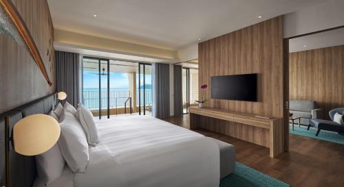 a hotel room with a bed and a television at PARKROYAL Langkawi Resort in Pantai Cenang