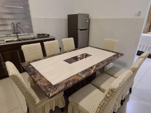 eine Küche mit einem Tisch mit Stühlen und einem Kühlschrank in der Unterkunft Kuala Selangor Cozy Homestay in Kuala Selangor