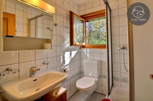 La salle de bains est pourvue d'un lavabo, de toilettes et d'un miroir. dans l'établissement Chalet Le Coeur, à Ovronnaz
