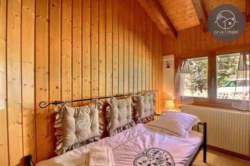 ein Schlafzimmer mit einem Bett in einer Holzwand in der Unterkunft Chalet Le Coeur in Ovronnaz