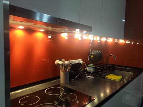 吉隆坡的住宿－Arcoris Soho 2bedroom 1-7pax Industrial Loft Style，厨房柜台配有炉灶和灯。