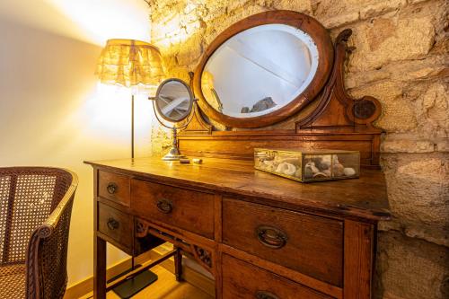 a wooden dresser with a mirror on top of it at Entre Bodegas Jerez in Jerez de la Frontera