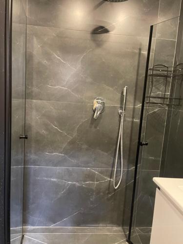 een douche met een glazen deur in de badkamer bij Meital house in Bat Yam